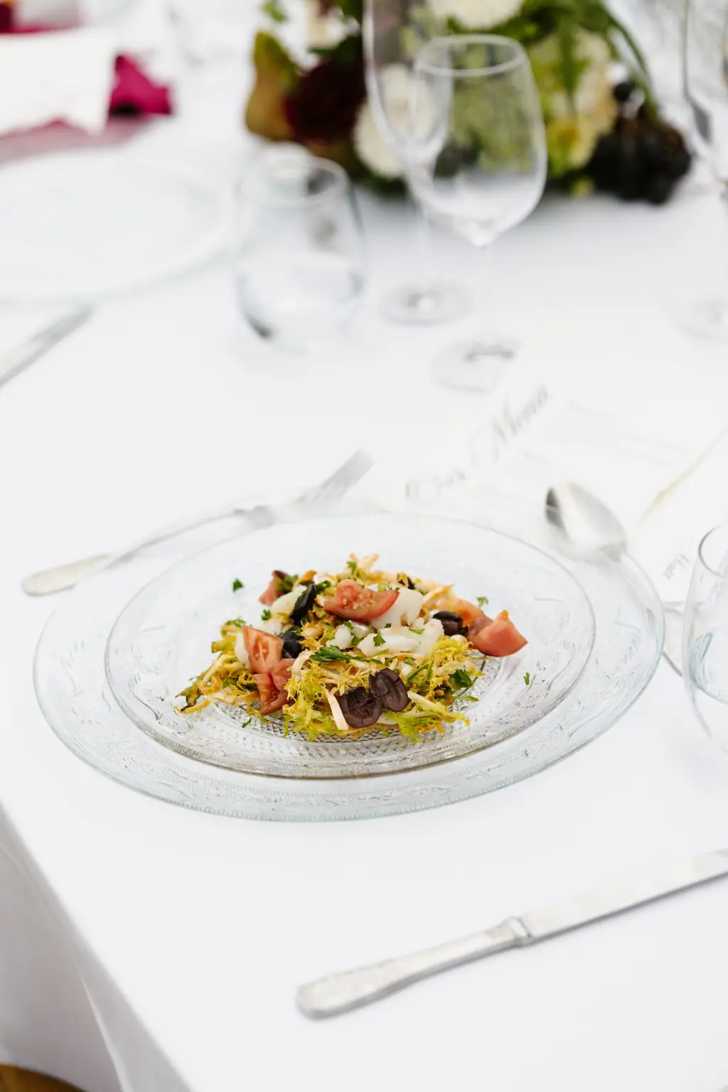 Una amanida de bacallà, tomàquet i olives negres emplatada